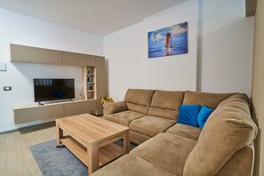 Apartamento luxo | Área de estar | TV de tela plana 110 cm com canais a cabo