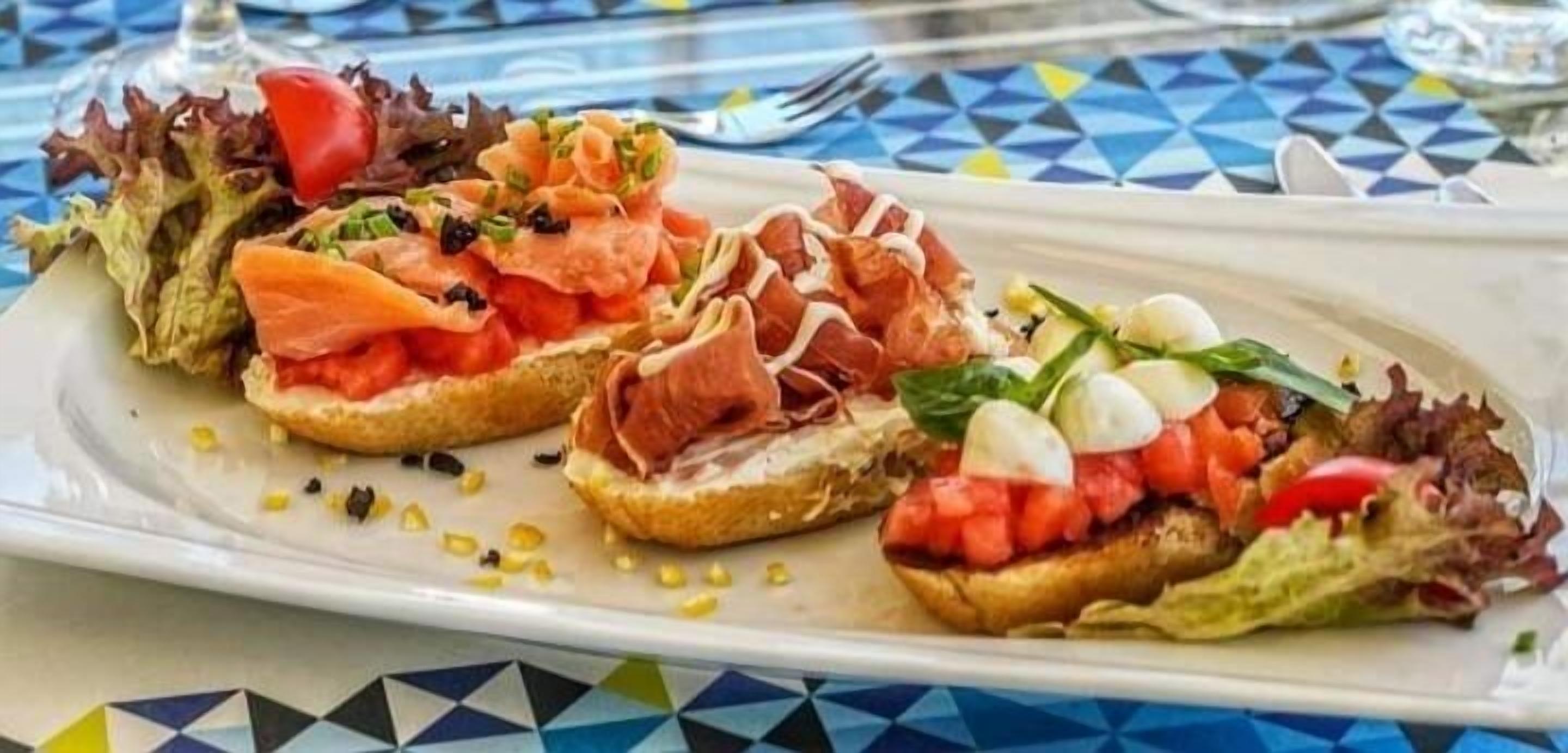 A plate of bruschetta with various toppings.