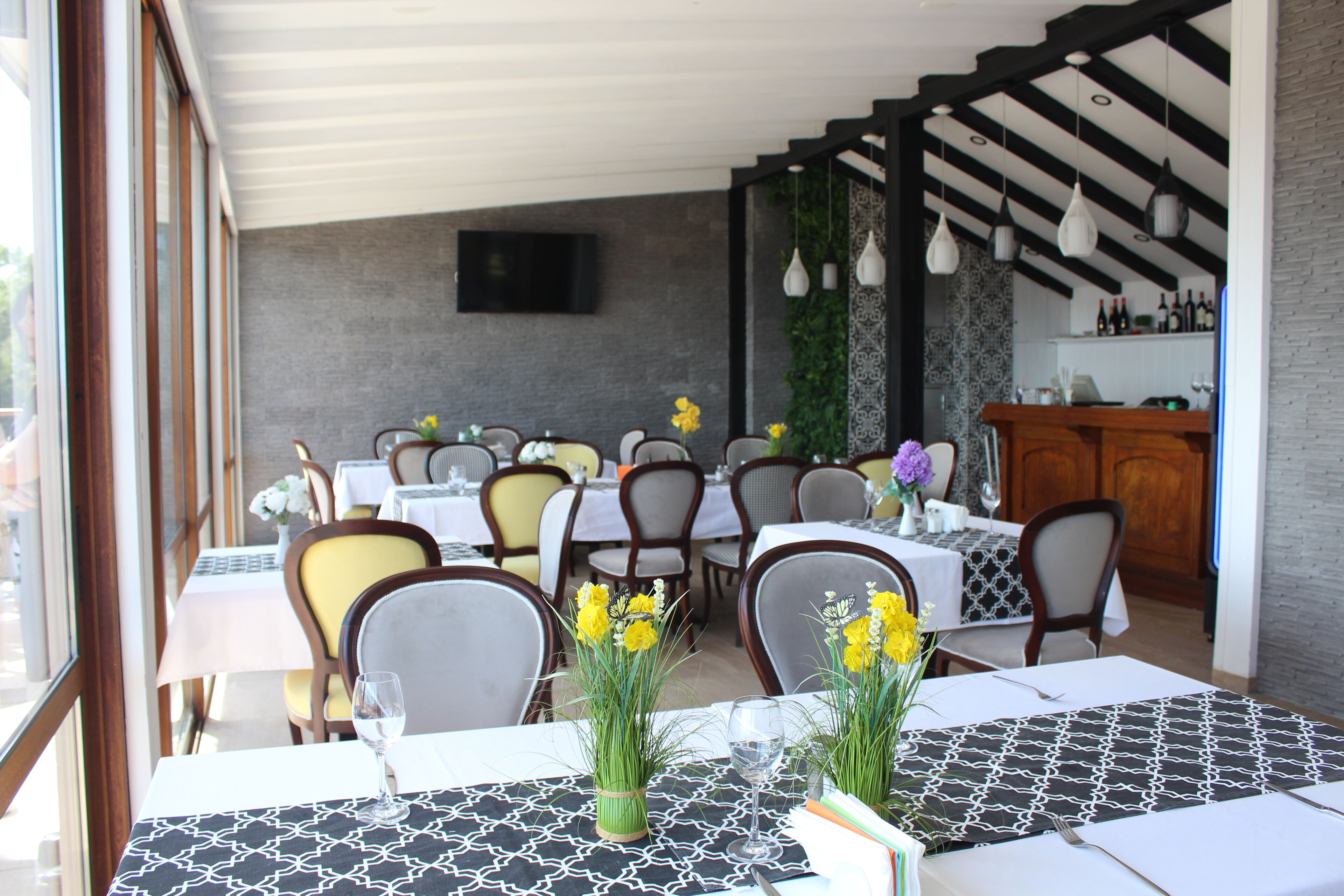 Un restaurante con varias mesas, sillas y una zona de bar.