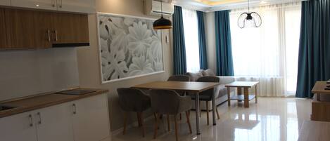 Una cocina moderna con armarios blancos, encimera de madera y una zona de comedor con mesa y sillas.