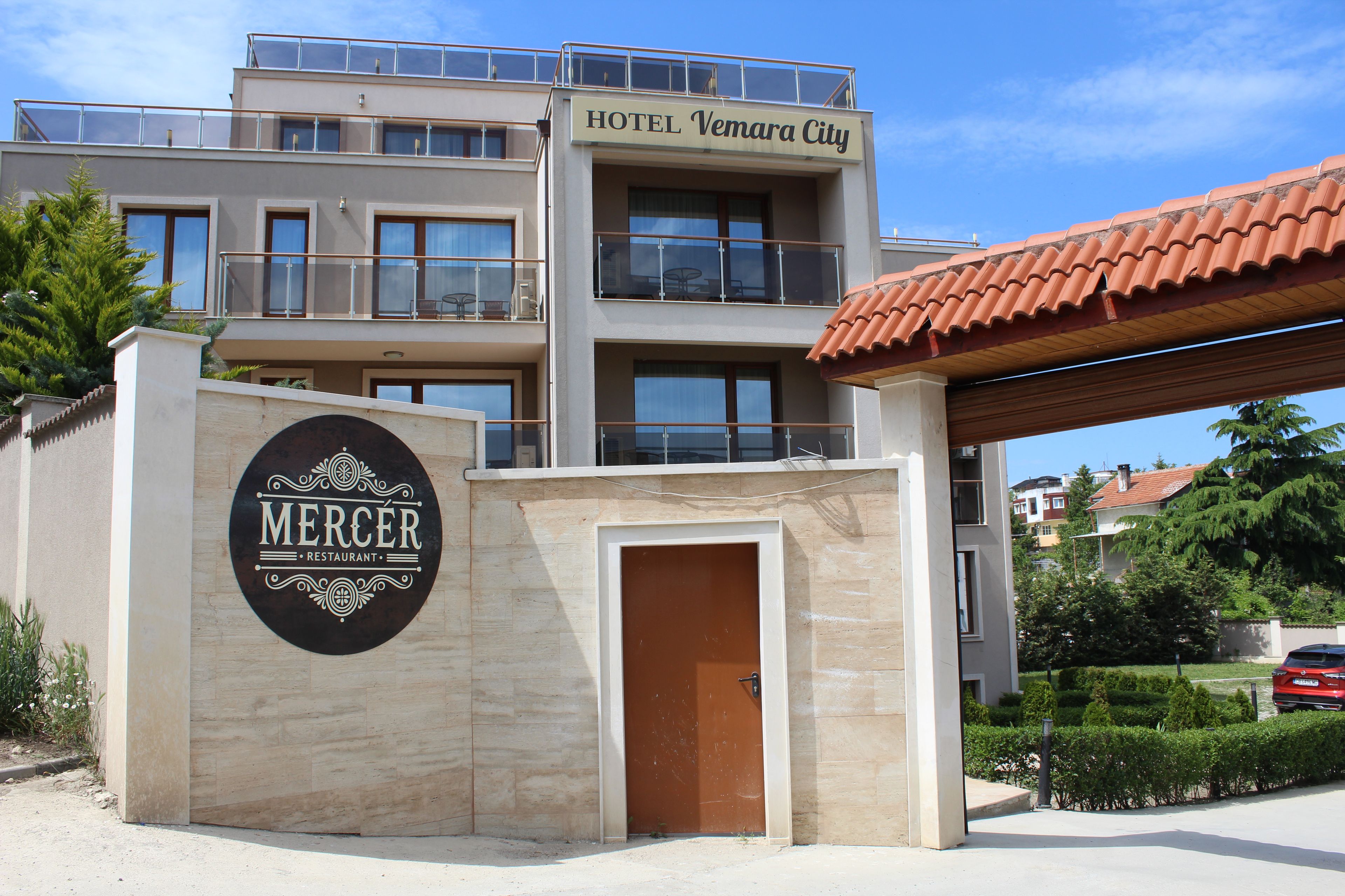 Un hotel llamado 'Hotel Vemara City' con un letrero que anuncia 'Mercer Restaurant'.