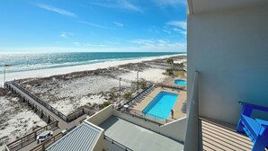 A beach view from a balcony with a pool and lounge chairs. - HEART OF GULF SHORES, GULF-FRONT BALCONY, POOL! | BEACHBALL PROPERTIES (Gulf Shores)