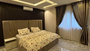 Un dormitorio moderno con una cama grande, una mesita de noche e iluminación integrada en el techo.