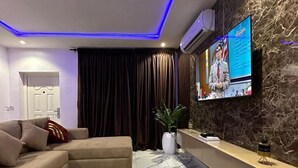Una sala de estar moderna con un sofá modular, una alfombra con diseño de mármol y una pared de acento de piedra.