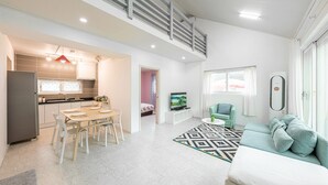 Eine moderne Wohnung mit Küche, Essbereich, Wohnzimmer und einem Balkon.