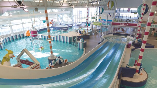 An indoor water park with a large pool, slides, and various water play areas. - Memorymakersholiday Sea View (Pwllheli)