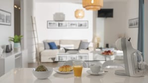 A modern kitchen with a coffee maker, croissants, and a glass of orange juice on the counter. - In the Heart of Porto Santo - Casa da Maresia (Porto Santo)