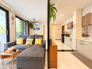 A modern living room with a grey sectional sofa, a wooden coffee table, and a small side table.