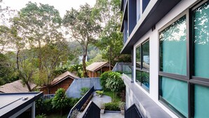 A modern building with large windows, a rooftop garden, and a staircase leading to an upper level. - A307- 2 Bedroom Serviced Apartment with Forest View at Ao Nang Beach (Tambon Ao Nang)