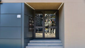 A building entrance with a set of steps leading up to a glass door.