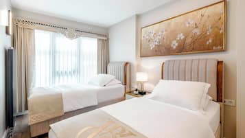 Ein Hotelzimmer mit zwei Betten, einem Gemälde, einem Nachttisch und einer Heizung.