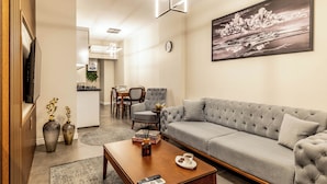 A modern living room with a grey sofa, a wooden coffee table, and a painting on the wall. - Bellavia Deluxe Apart (Istanbul)