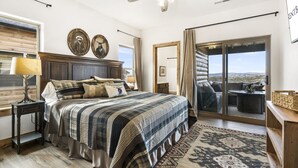 A bedroom with a large bed, a ceiling fan, a window with blinds, and a view of the outdoors. - Ozark Sunset View Log Cabin with $400 Daily Activities Included & Pickleball (Branson)
