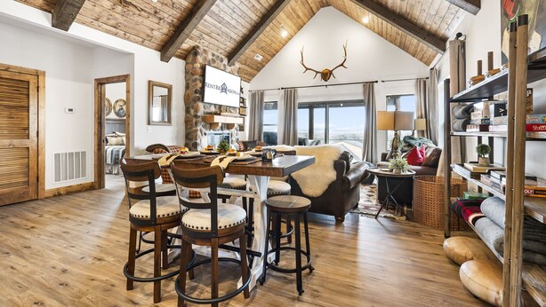 A spacious living area with a high wooden ceiling, a fireplace, and a large window offering a view. - Ozark Sunset View Log Cabin with $400 Daily Activities Included & Pickleball (Branson)