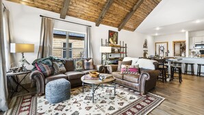 A cozy living room with a wooden ceiling, a fireplace, a dining area, and a kitchen. - Ozark Sunset View Log Cabin with $400 Daily Activities Included & Pickleball (Branson)