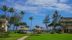 Un resort con piscina, palmeras y vista al océano.