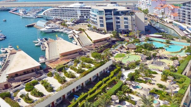 A resort with multiple swimming pools, a marina with boats, and a variety of outdoor seating areas. - Britain in the Sun at Luxurious Ocean Village (Gibraltar)