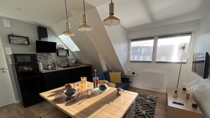 Una cucina moderna con isola centrale, elettrodomestici neri e un'area pranzo con tavolo e sedie in legno.