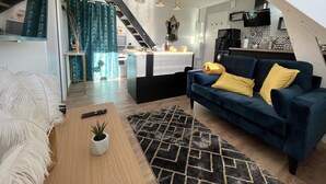 Un loft moderno con angolo living, cucina e zona pranzo.