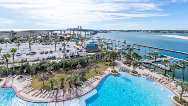 A resort with a large pool, palm trees, and a marina. - Family-Friendly Two Bedroom Unit with Phenomenal Gulf and Bay Views. Complimentary Boat Slip! (Orange Beach)