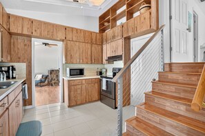 A kitchen with wooden cabinets, a microwave, a toaster, and a stove.