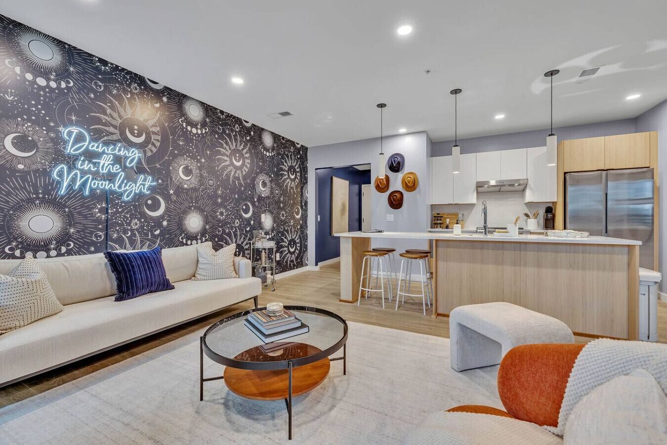 A modern living room with a sofa, coffee table, and a kitchen area with a bar.