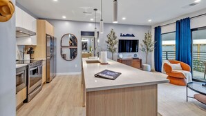 A modern kitchen with a central island, built-in oven, and a dining area with a view. - Dancing in the Moonlight in Downtown Nashville, Walk to Broadway (Nashville)