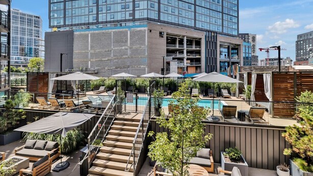 A rooftop pool area with lounge chairs, umbrellas, and a staircase leading to an upper level. - Dancing in the Moonlight in Downtown Nashville, Walk to Broadway (Nashville)