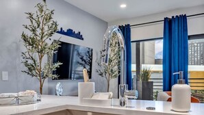 A modern kitchen with a large sink, wooden cabinets, and a decorative plant. - Dancing in the Moonlight in Downtown Nashville, Walk to Broadway (Nashville)