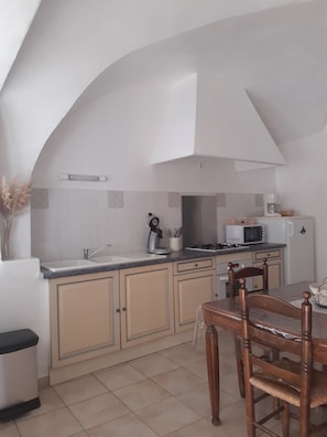 Compact kitchen with sink, microwave, and stove, perfect for meal preparation and dining.