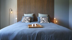 A neatly made bed with a tray of mugs and a candle, a striped wall, and a floor lamp. - Magnifique Maison à 5 mn de Saint Rémy de Provence Avec Piscine, Cuisine D'été (Graveson)
