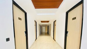 A hotel corridor with doors numbered 118 and 117, leading to rooms. - Hotel Holiday Grand Near Expo Mart (Greater Noida)