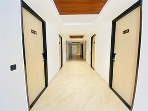 A hotel corridor with doors numbered 118 and 117, leading to rooms. - Hotel Holiday Grand Near Expo Mart (Greater Noida)