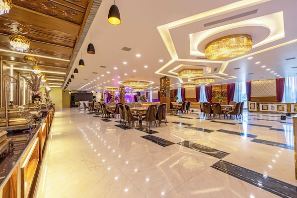 Eine großzügige Hotelhalle mit poliertem Marmorboden, eleganten Kronleuchtern und einer langen Rezeption.