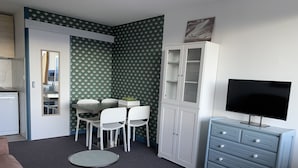 A compact living space with a dining area, a television, and a cabinet.