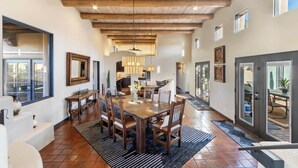A spacious dining area with a wooden table and chairs, large windows, and a high ceiling with exposed beams. - Experience luxury at Sedona Red Mountain Retreat, a spacious 3-bedroom house with stunning views. (Sedona)