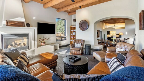 A spacious living room with leather sofas, a fireplace, and a ceiling fan. - Experience luxury at Sedona Red Mountain Retreat, a spacious 3-bedroom house with stunning views. (Sedona)