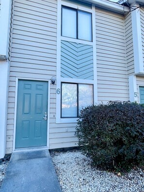 A two-story building with a green door and a small window. - Beautiful and Tranquil Cherry Grove Beach (North Myrtle Beach)