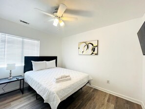A bedroom with a bed, a nightstand, a ceiling fan, and a window with blinds. - Beautiful and Tranquil Cherry Grove Beach (North Myrtle Beach)