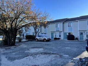 A residential area with a row of two-story houses, a gravel driveway, and a parked car. - Beautiful and Tranquil Cherry Grove Beach (North Myrtle Beach)