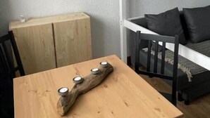 Ein Schlafraum mit Etagenbetten, einem Holztisch und einem kleinen Schrank.
