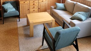 A wooden interior with a sofa, two chairs, a TV, and abstract art on the wall. - New! Haus Seebrise - at Useriner See - Müritz National Park (Userin)