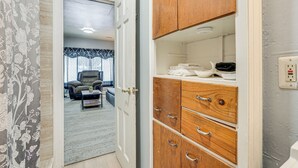 A room with a wooden cabinet, a white door, and a view into another room with a sofa and a coffee table. - Kalamazoo Vacation Rental Near Golf & Parks! (Kalamazoo)