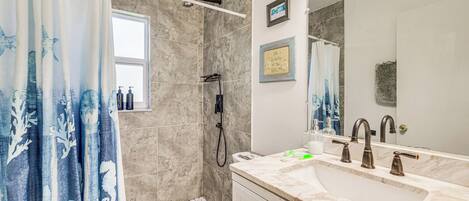 A bathroom with a shower, toilet, and sink.