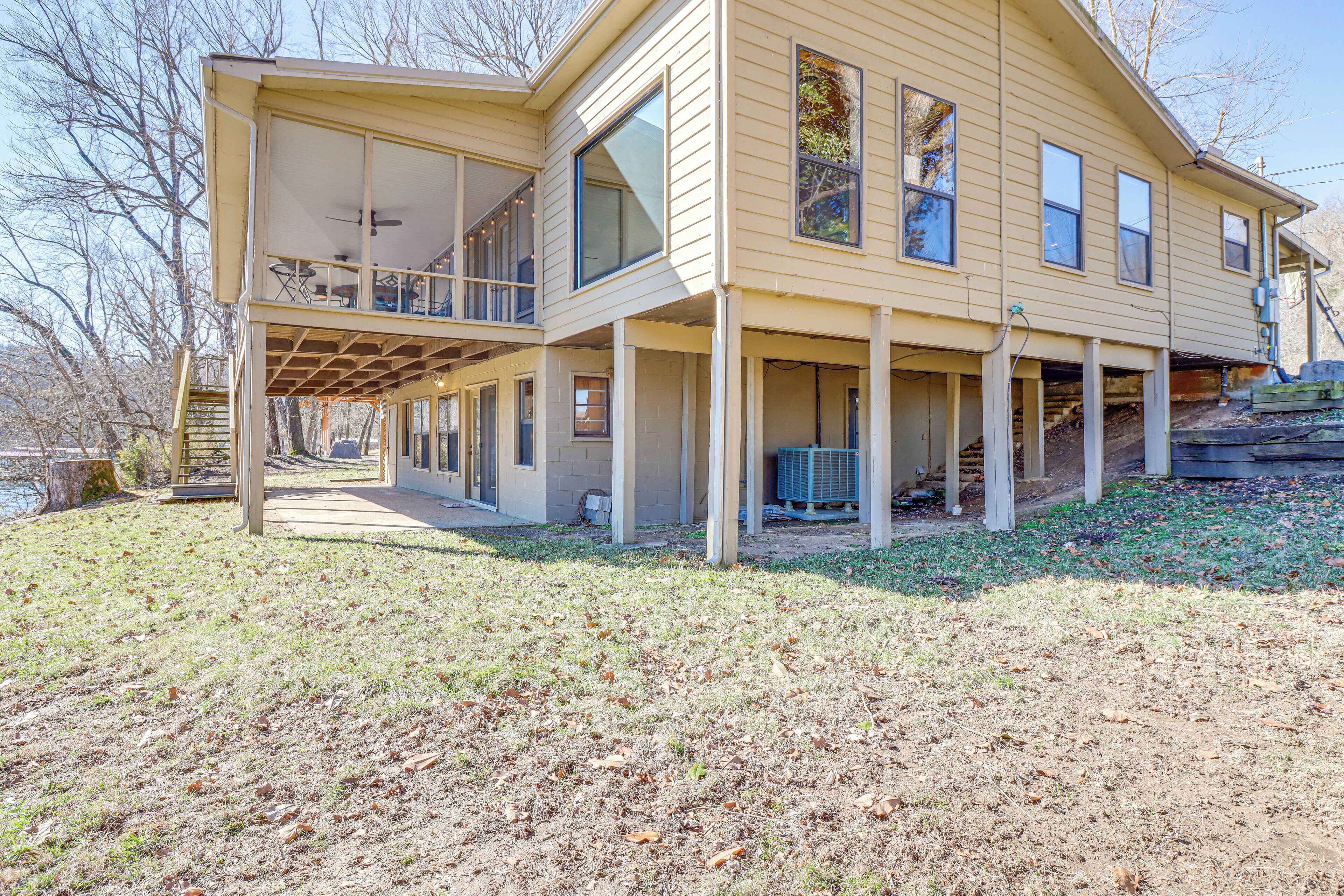 A two-story house with a covered porch and a large window.