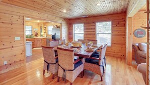 A wooden cabin interior with a dining area, kitchen, and a cozy seating area. - Please Note: No Boat Slip Available for Dock (Flippin)