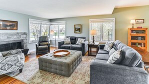 A living room with a fireplace, two sofas, a coffee table, and a bookshelf.