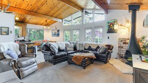 A spacious living room with leather sofas, a fireplace, and large windows. - Enchanted Woodland Cabin Near Yosemite w/ Fire Pit (Groveland)