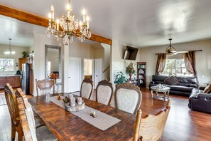 A spacious living room with a wooden dining table, ornate chairs, a chandelier, and a leather sofa. - Peaceful Heber-overgaard Cabin w/ Deck & Grill! (Overgaard)