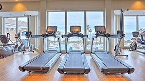 A gym with treadmills, exercise bikes, and a view of the ocean. - Florida Resort Condo: Walk to Pensacola Beach! (Pensacola Beach)